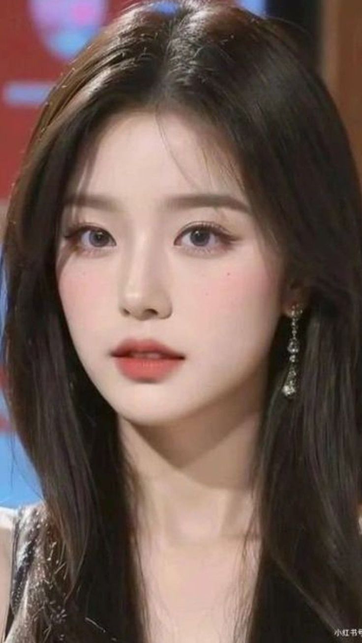 Woman with long black hair and earrings in a close-up portrait