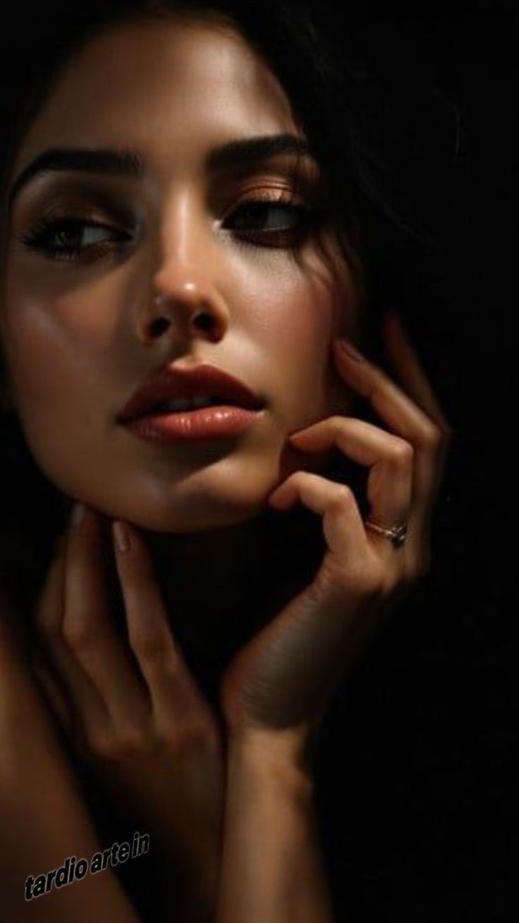 Woman with dark hair and dramatic lighting on her face and hands
