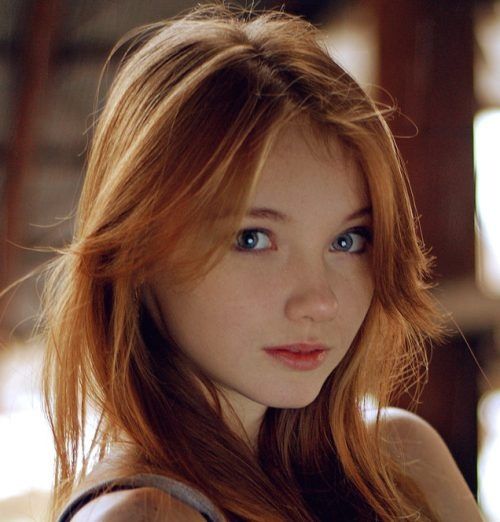 Young woman with red hair and blue eyes looking at the camera