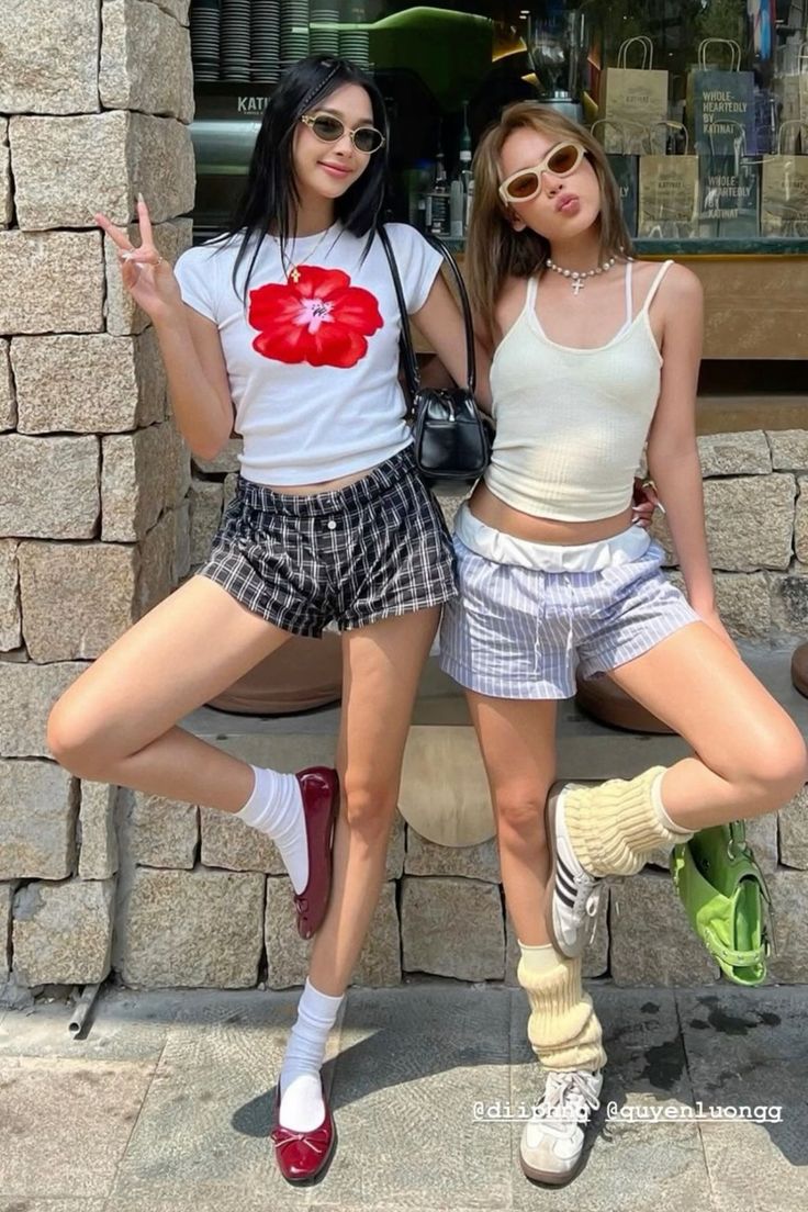 Two women posing outdoors in casual summer outfits