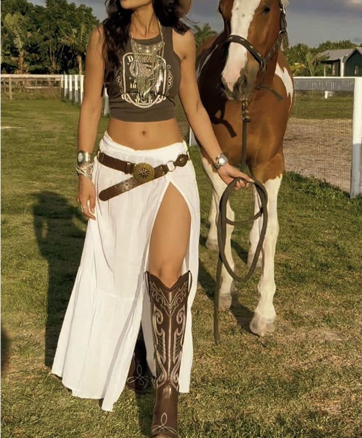 Woman in a crop top and long skirt with a horse outdoors