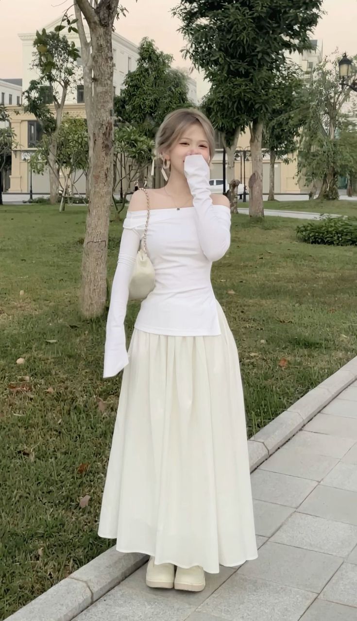 Woman in a white off-shoulder top and long skirt outdoors