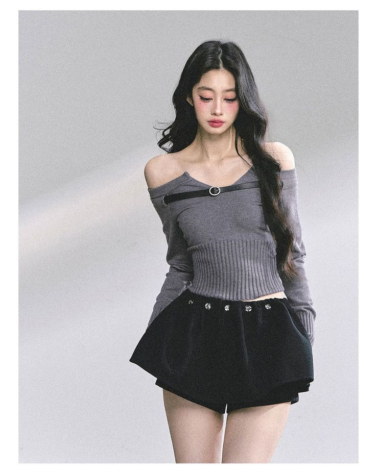 Woman with long black hair wearing an off-shoulder top and black shorts