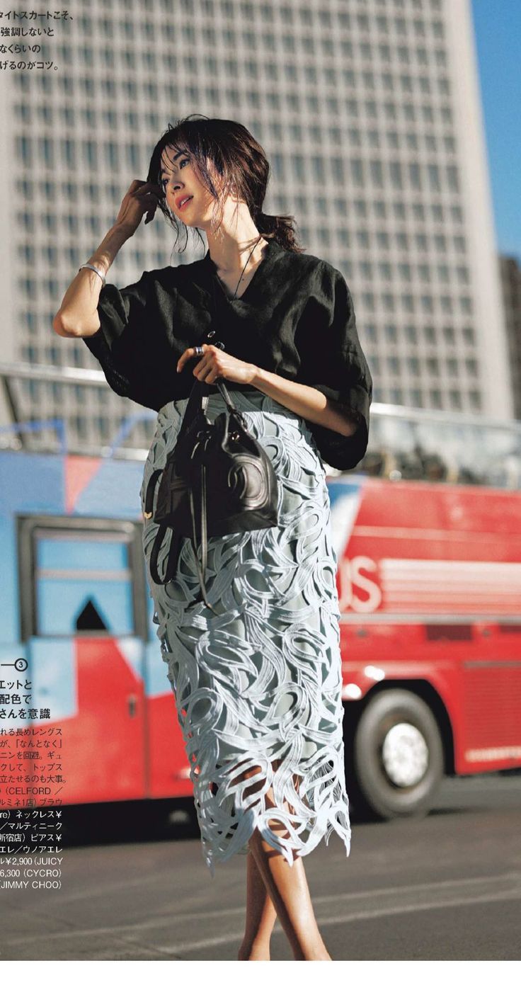Woman in a black top and lace skirt on a city street