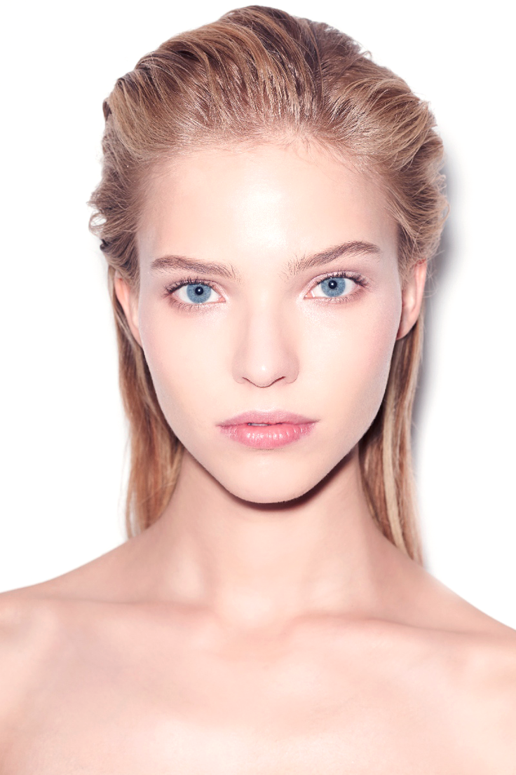 Woman with blonde wet hair and blue eyes against a white background