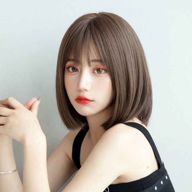 Woman with short brown hair and red lipstick wearing a black top