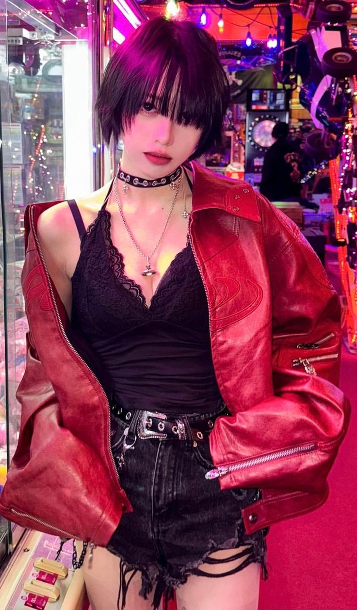 Woman in a red leather jacket and black lace top in a neon-lit arcade