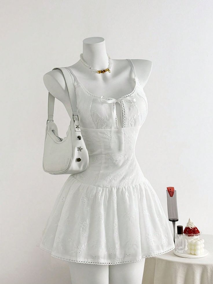 White dress on a mannequin with a handbag and necklace
