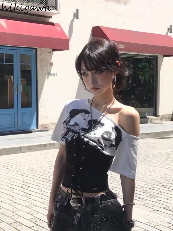 Woman with black hair wearing an off-shoulder top and corset on a street