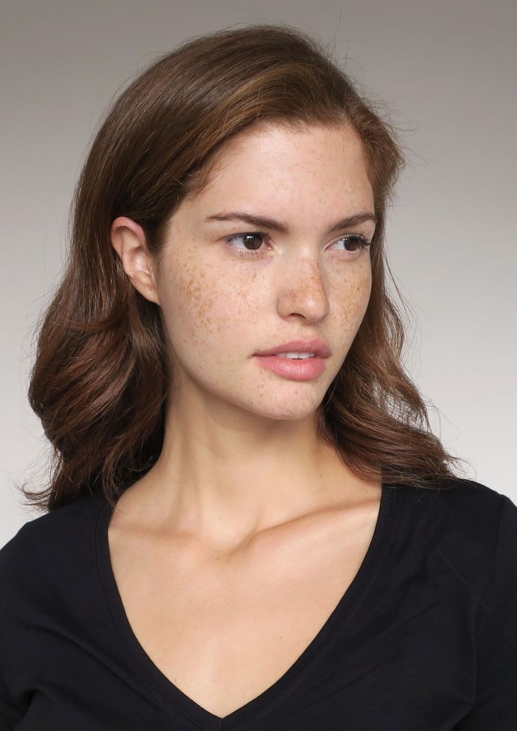 Woman with freckles and brown hair wearing a black v-neck shirt
