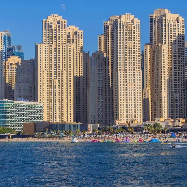 Cityscape with tall buildings overlooking a beach and ocean under a blue sky