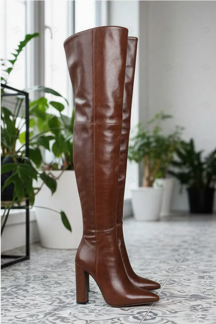 Pair of brown thigh-high boots with high heels on a tiled floor indoors