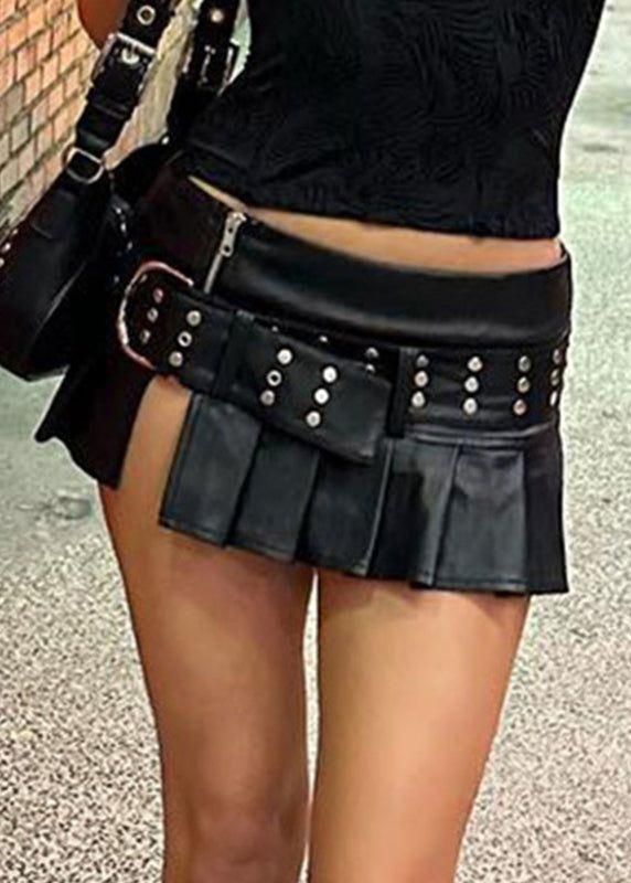 Person wearing a black pleated mini skirt and cropped top