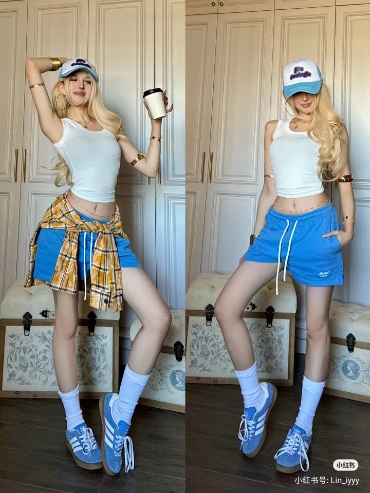 Woman with long blonde hair in a white tank top and blue shorts indoors