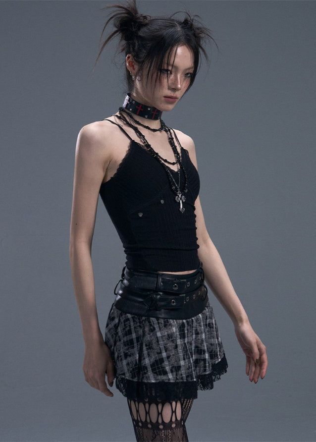 Woman in gothic-style clothing with messy buns and layered necklaces