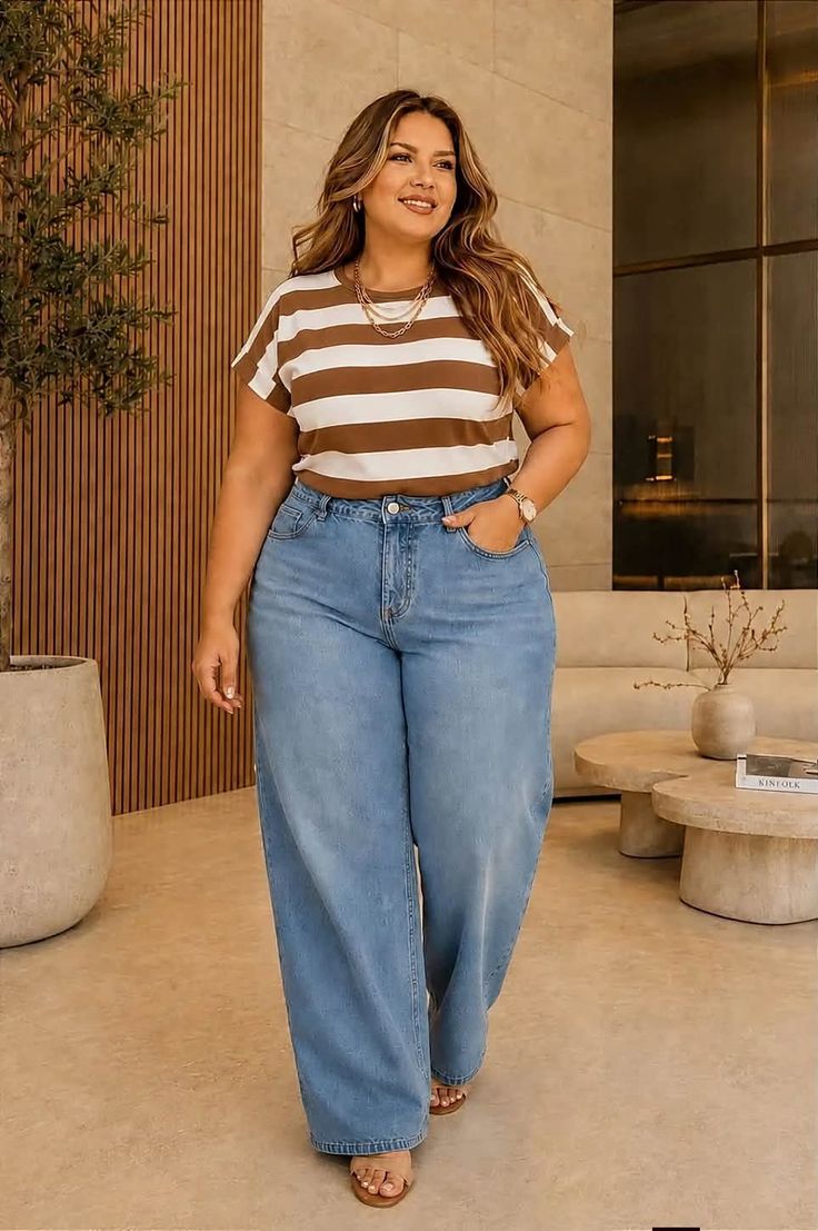 Woman with long hair wearing a striped shirt and wide leg jeans indoors