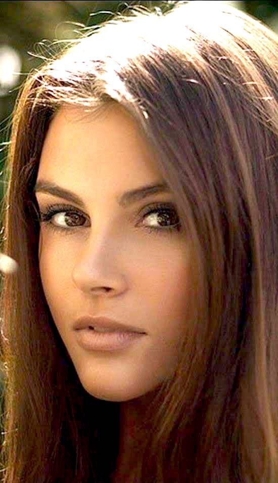 Close-up portrait of a woman with long brown hair looking to the side