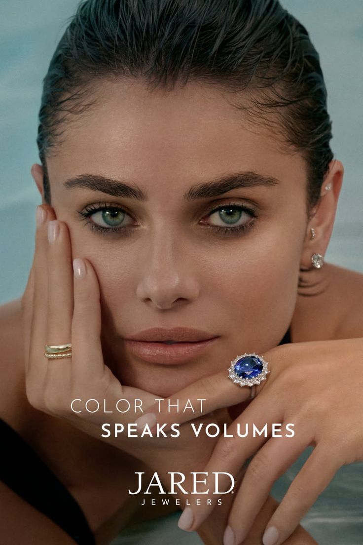 Woman with wet hair and green eyes wearing a sapphire ring and earrings