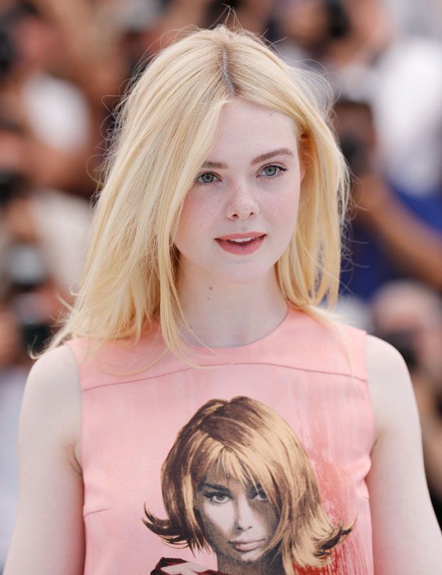 Young woman with blonde hair and freckles wearing a pink top