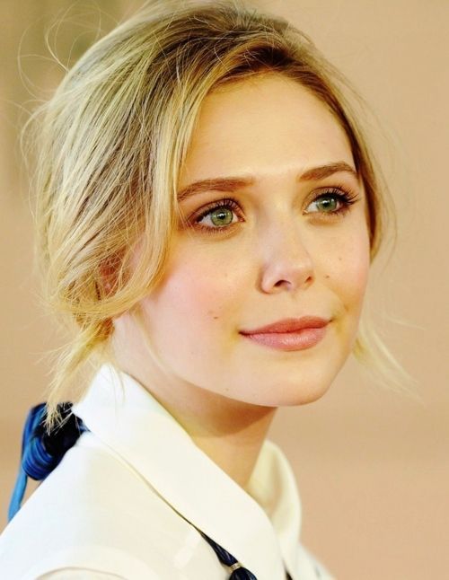Woman with blonde hair and green eyes wearing a white shirt