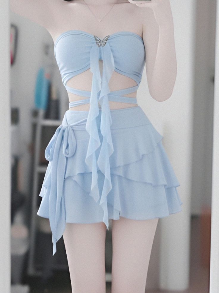 Person in a light blue strapless top and ruffled skirt with a butterfly accessory