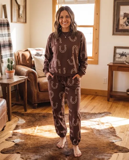 Woman in brown loungewear with a horseshoe pattern standing on a cowhide rug