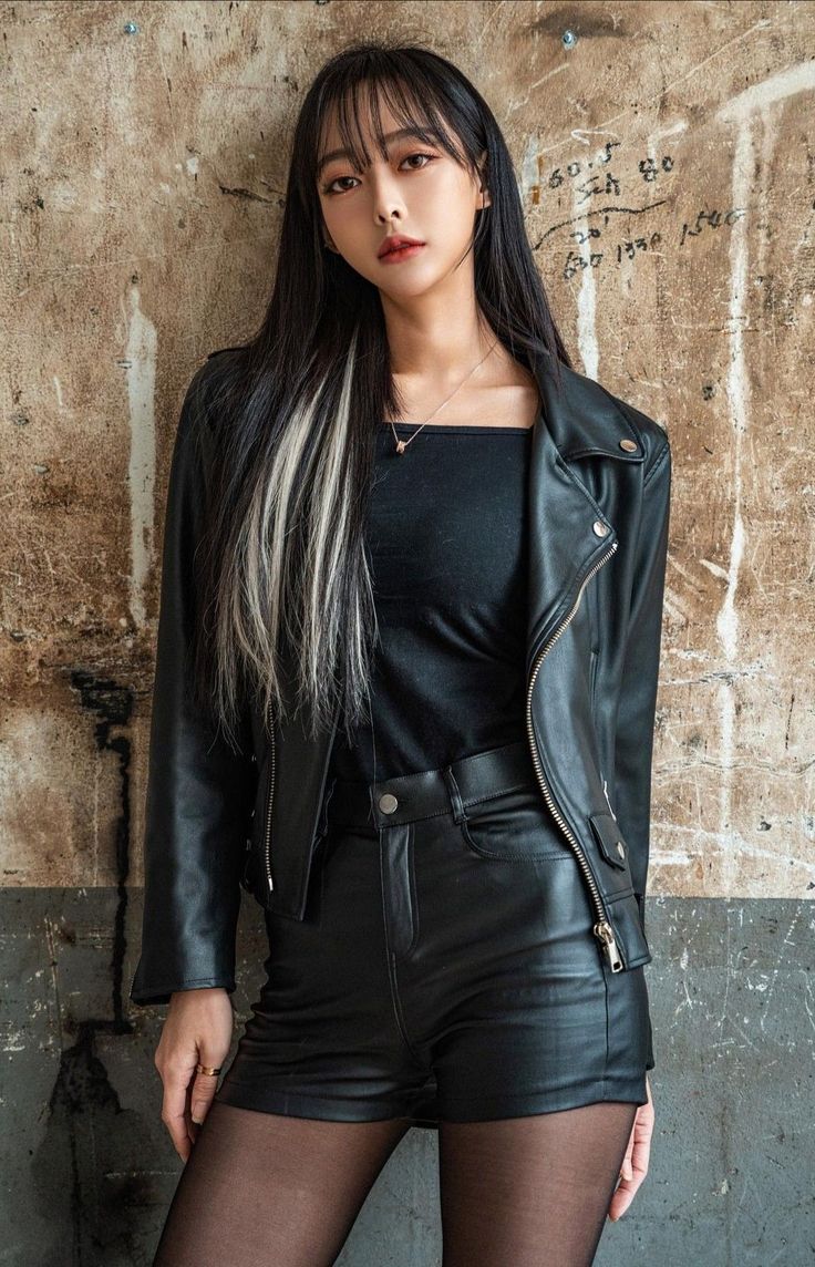 Woman in a black leather jacket and shorts with blonde streaks in her hair