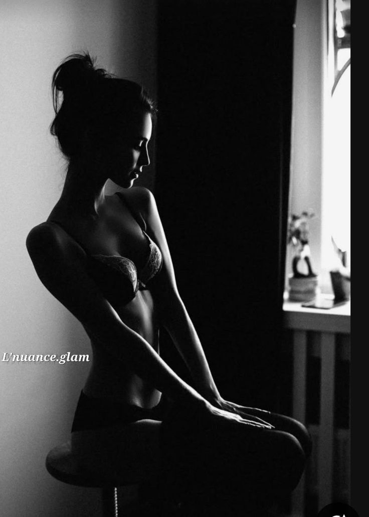 Woman in lingerie with dramatic backlight, shot in black and white