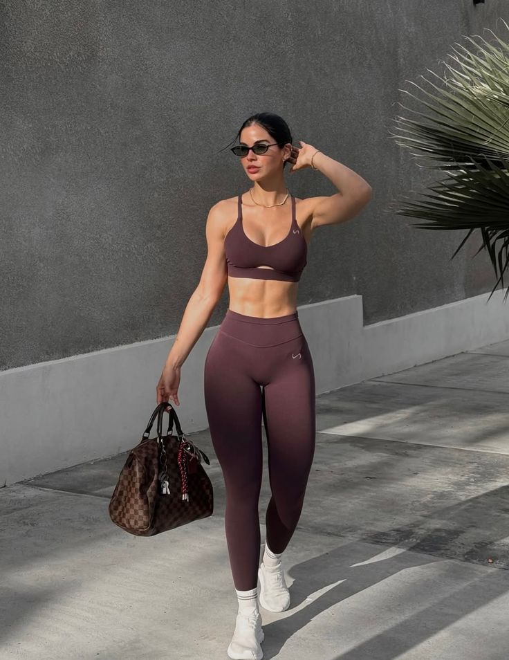 Woman in athletic wear and sunglasses walking outdoors