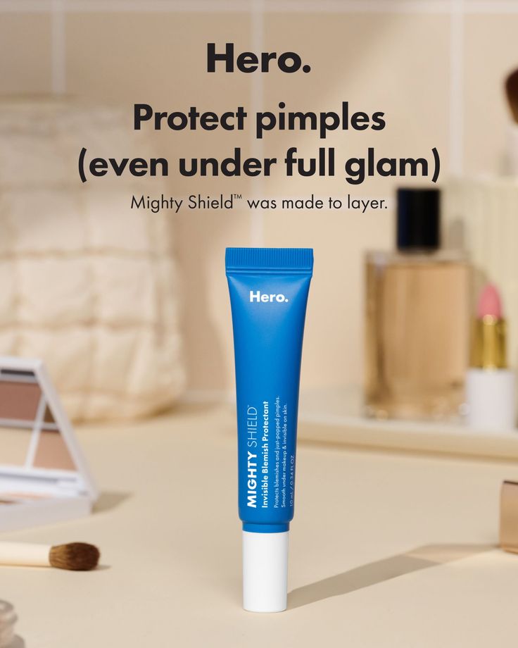 Blue tube of blemish protectant surrounded by makeup products on a vanity