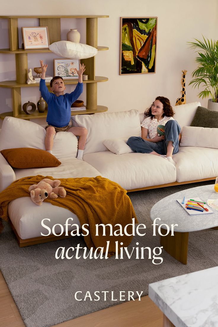 Two children playing in a bright living room with a white sofa
