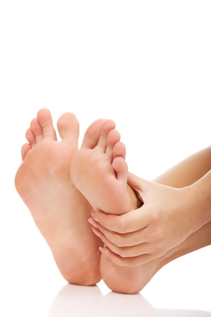 Hands massaging a foot against a clean white background