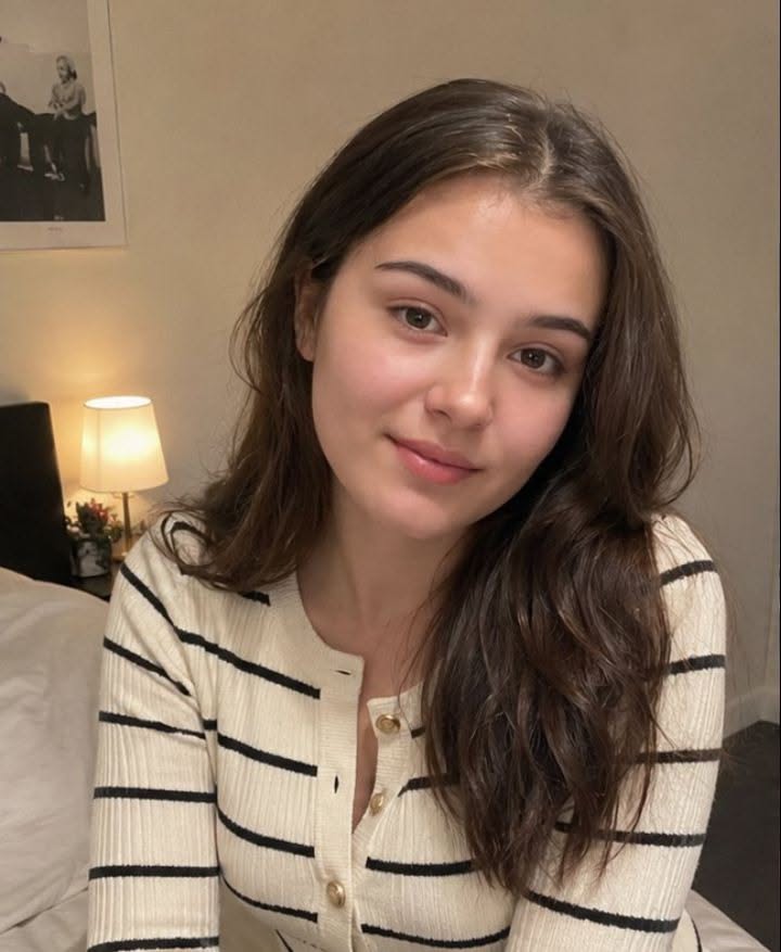 Woman with long brown hair wearing a striped cardigan indoors