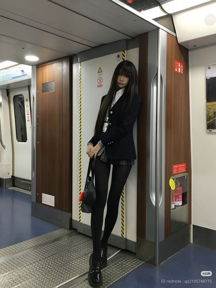 Person in a school uniform and black tights standing in a subway car