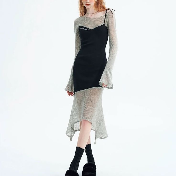 Woman in a black dress with a sheer long-sleeved top in a studio