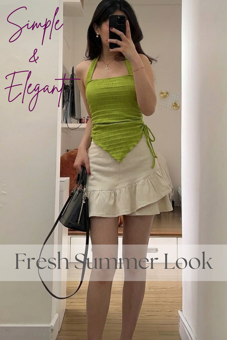 Woman in a green halter top and a beige ruffle mini skirt holding a black handbag