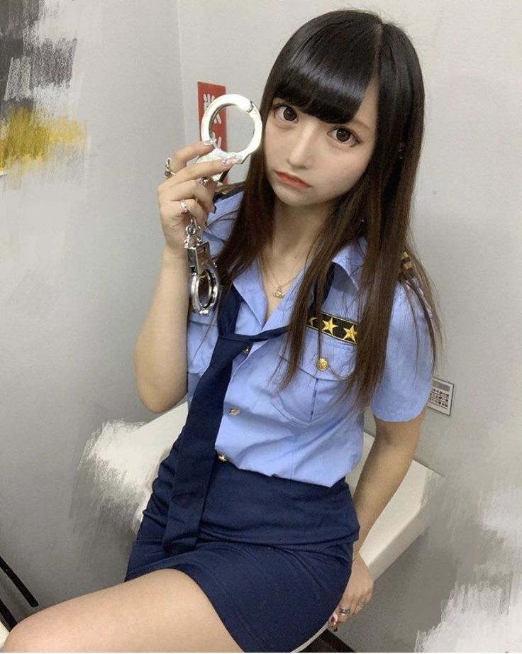 Woman in a police uniform holding handcuffs with a provocative pose