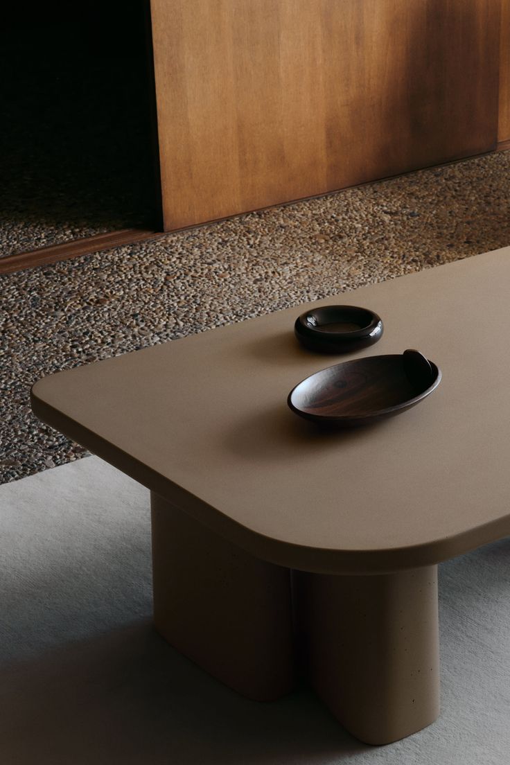 Minimalist coffee table with two wooden bowls on a terrazzo floor