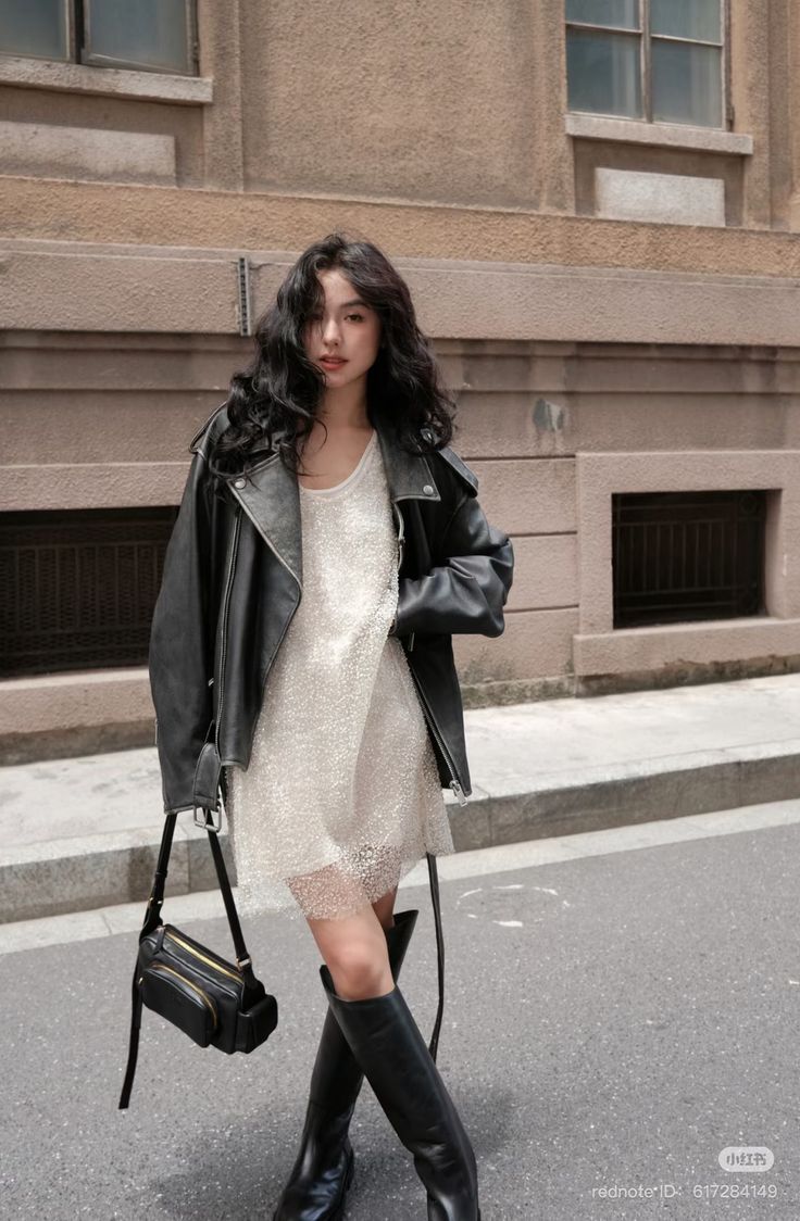 Woman in a black leather jacket and sparkly dress on a street