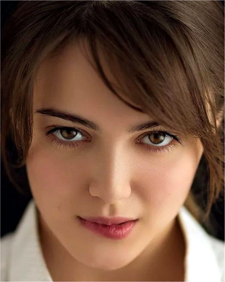 Close up portrait of a woman with brown hair and eyes, wearing a white shirt