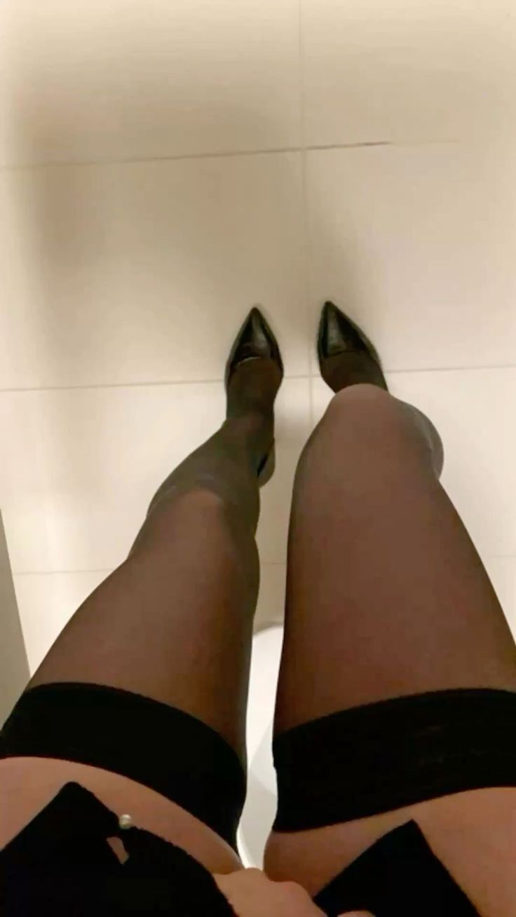 Person wearing black stockings and high heels from a low angle perspective