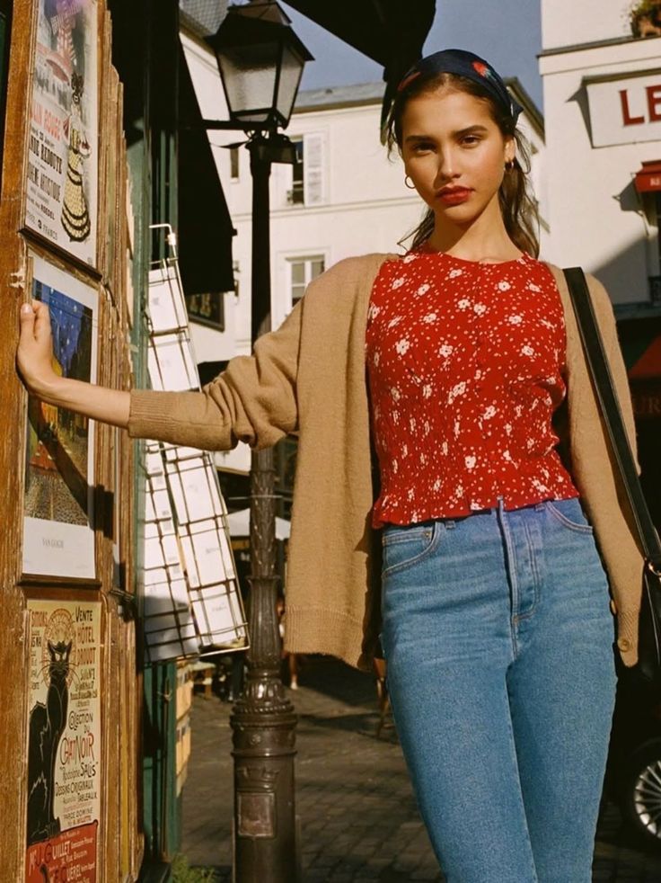 Woman in a red floral top and blue jeans on a sunny street