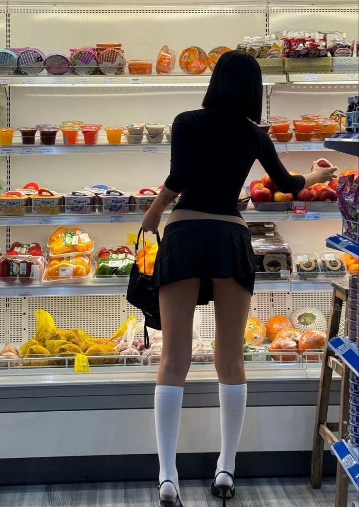 Woman in a black top and mini skirt shopping in a supermarket