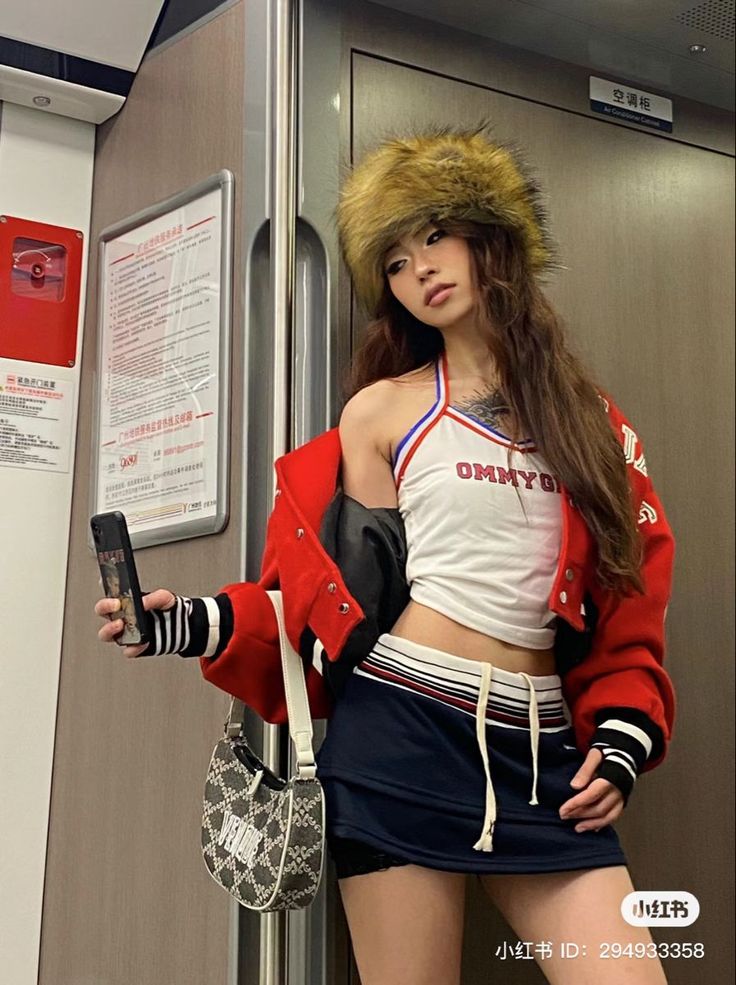 Woman in a fur hat, red jacket, and crop top in a subway car