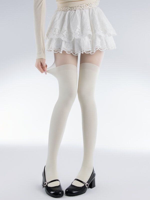 Person in a white lace skirt and thigh-high socks with Mary Jane shoes