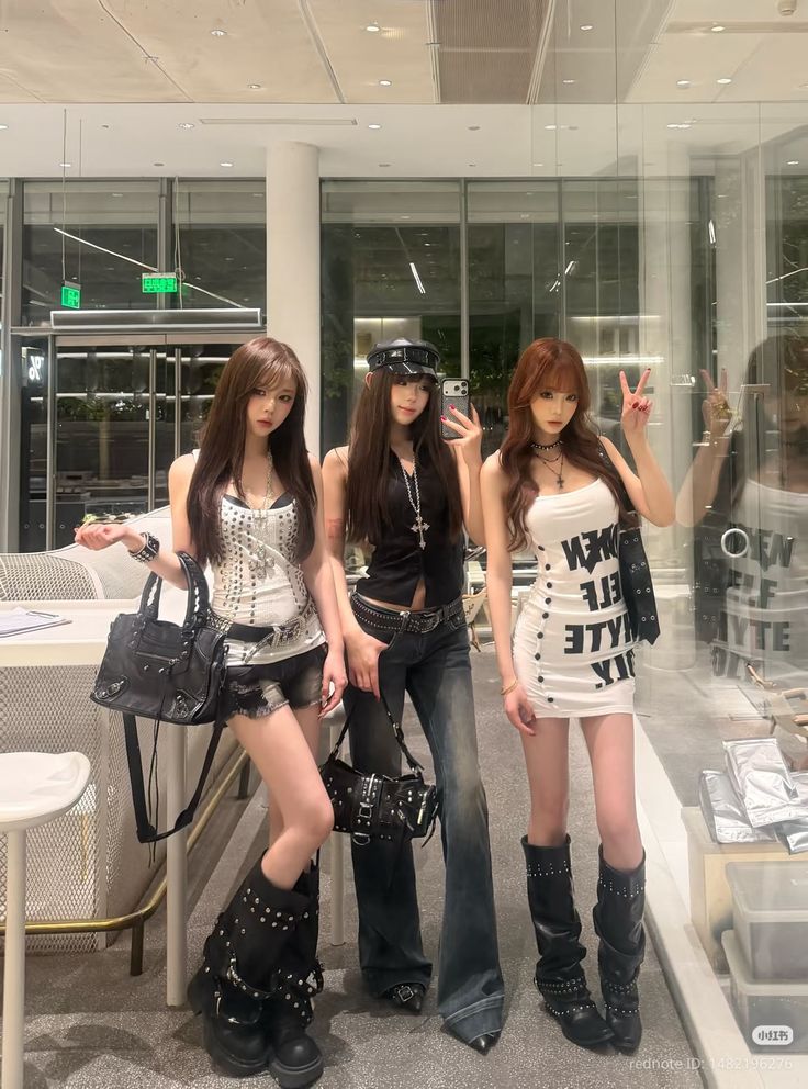Three women in gothic-inspired outfits posing indoors