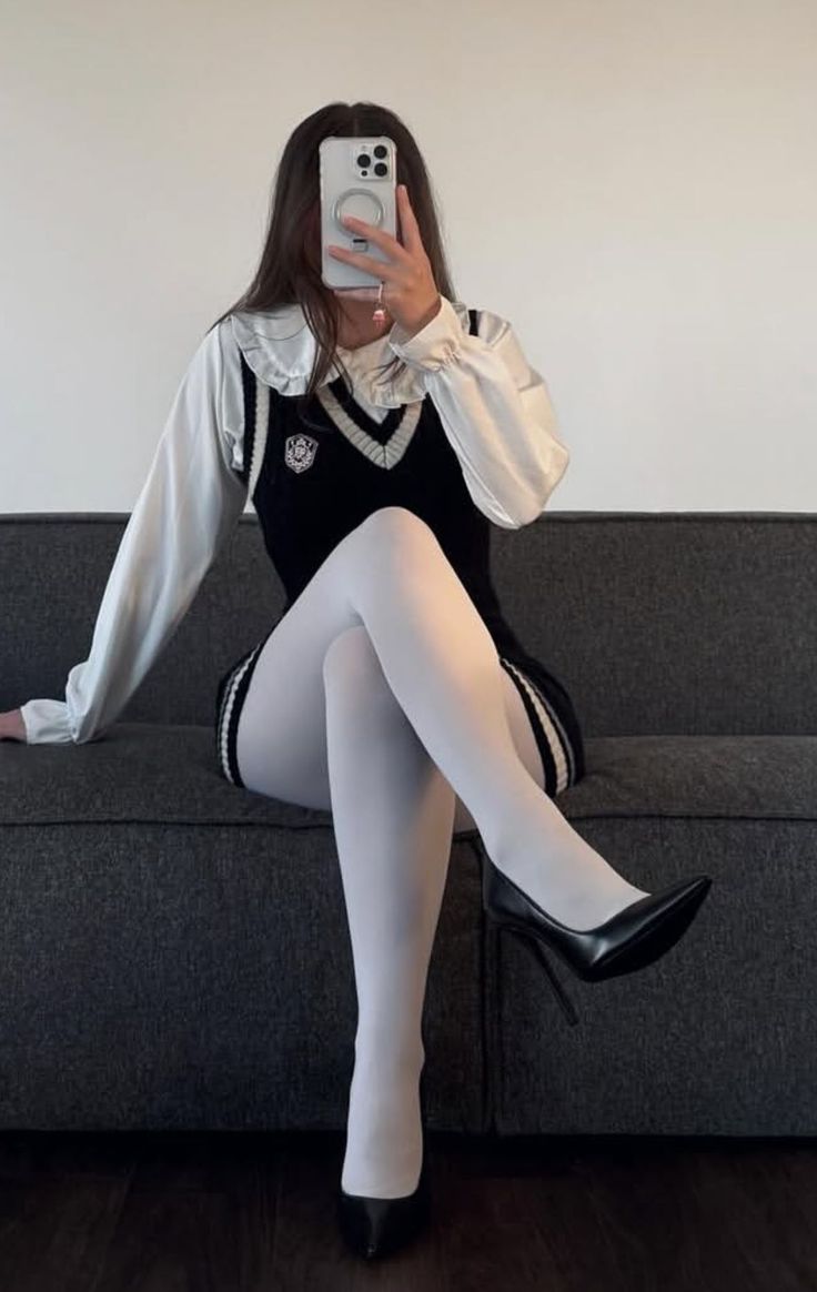 Person in a school uniform and white tights sitting on a couch