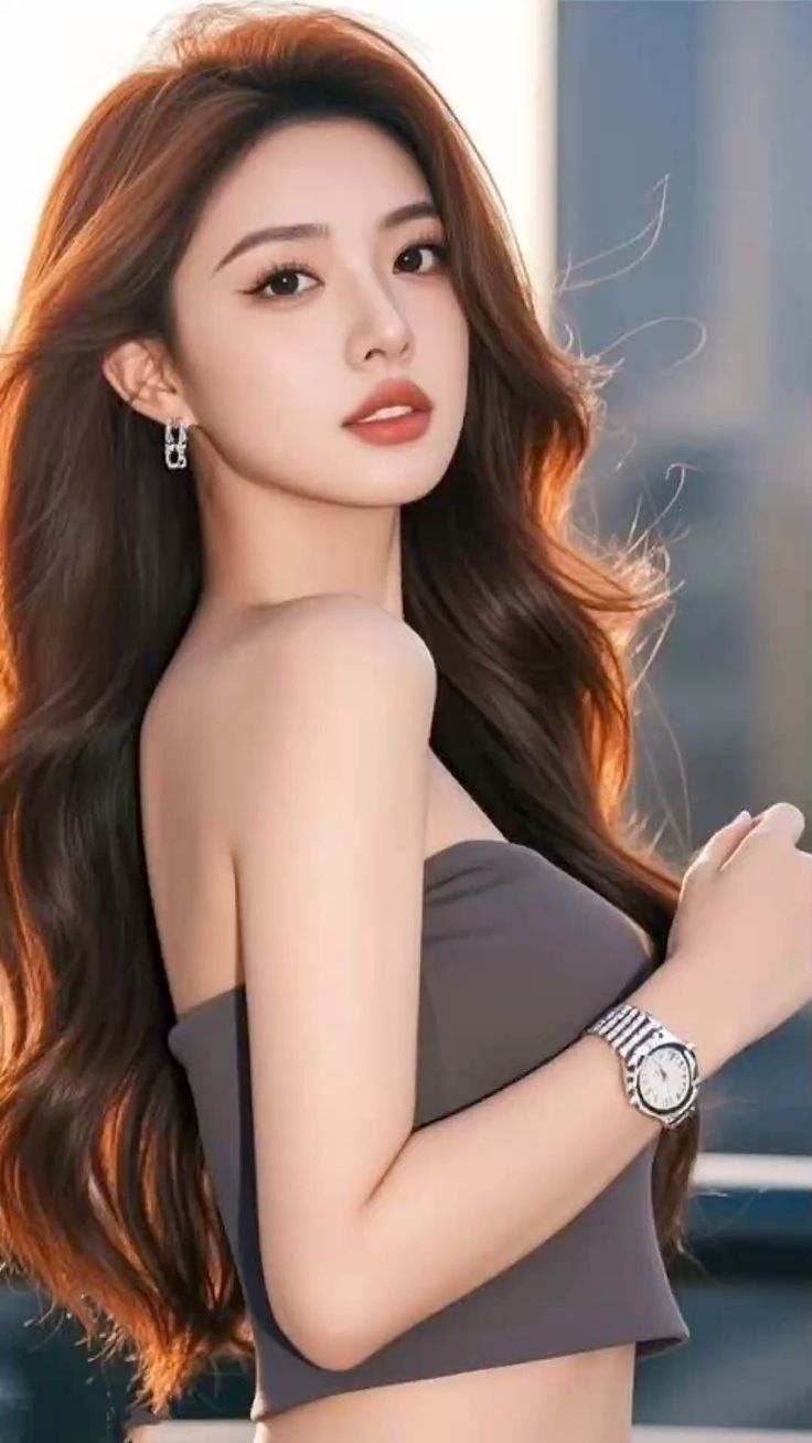 Woman with long brown hair wearing a strapless top and watch