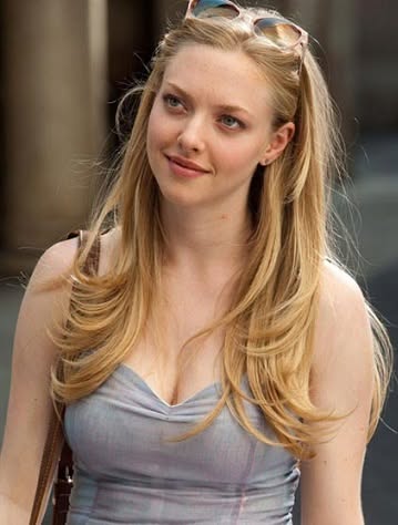 Blonde woman with sunglasses on her head wearing a light blue top outdoors