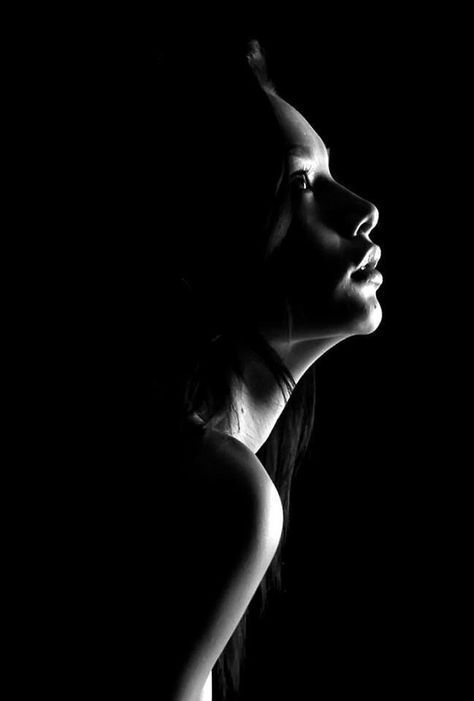 Woman's profile in dramatic black and white lighting with exposed shoulder